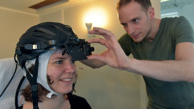 Studienleiterin Dr. Barbara Schmidt vom Institut für Psychologie der Universität Jena demonstriert die Technik für das Experiment, bei dem die Wirkung von Sicherheits-Accessoires, wie etwa die eines Fahrradhelms, auf das Risikoverhalten untersucht wird. Im Hintergrund assistiert Psychologie-Student Jona Ebker.