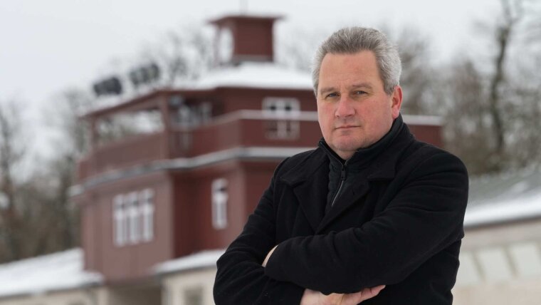 Porträtaufnahme von Prof. Dr. Jens-Christian Wagner vor dem Eingangsgebäude des ehemaligen Konzentrationslagers Buchenwald